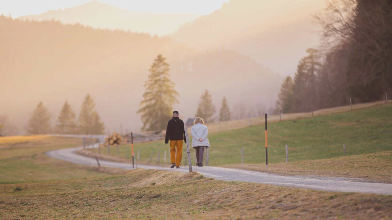 An older adult walking at a brisk, confident pace outdoors.